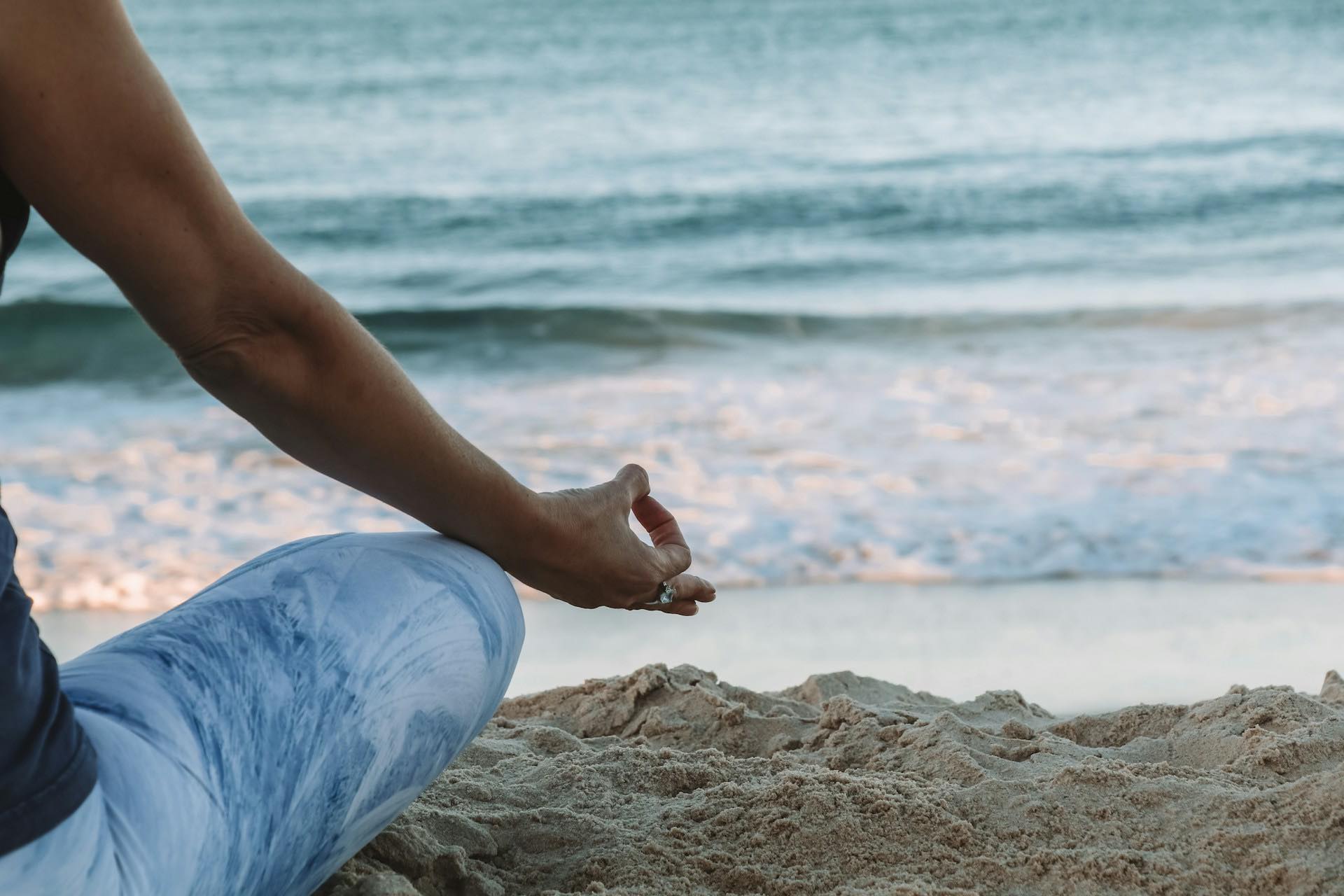 person meditating on the beach by the sea